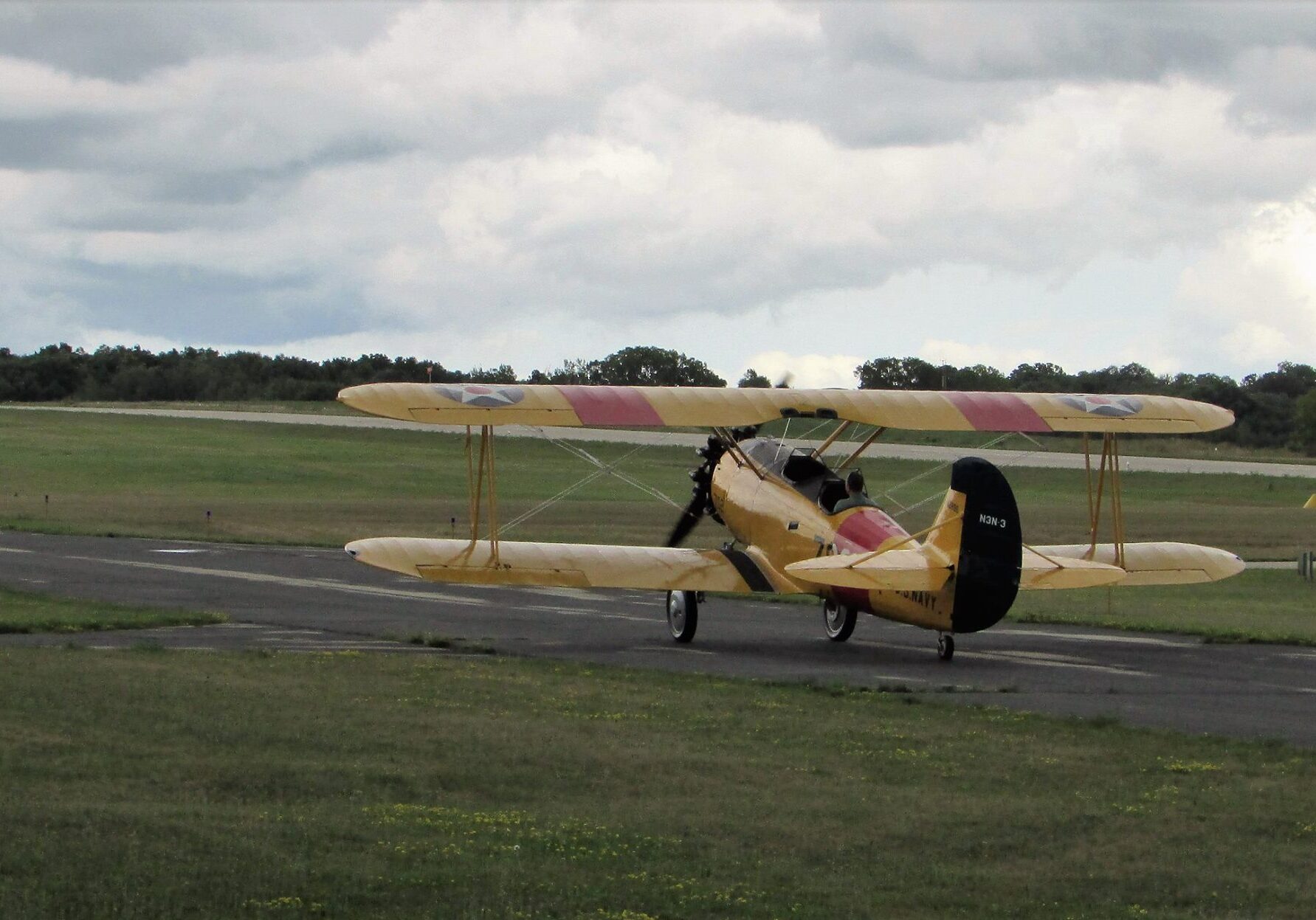 Yellow bi-plane on taxiway